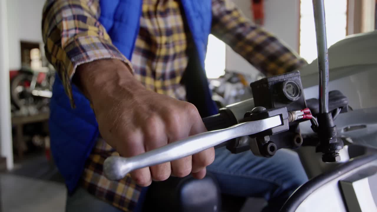 mecánico masculino reparando scooter en el garaje de reparación 4k