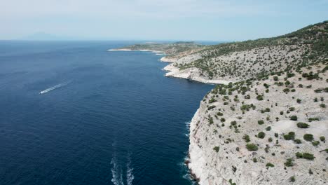 aerial view over a seaside cliff with turquoise water and small beaches close to the monastery of the archangel michael, red boat, thassos, greece, europe