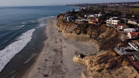 a stunning aerial drone shot, flying along the coastline with beautiful beach houses, solana beach - san diego - california