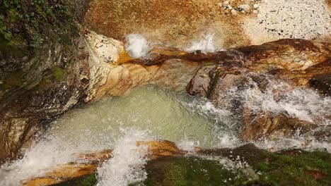 Entspannender-Wasserfall-Im-Orangefarbenen-Felsen,-Aufnahme-Von-Oben,-60-Fps