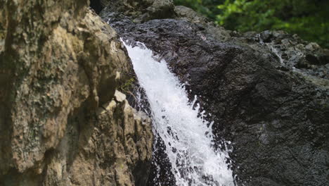 slow motion close up shot of clean water running from rocks of waterfalls