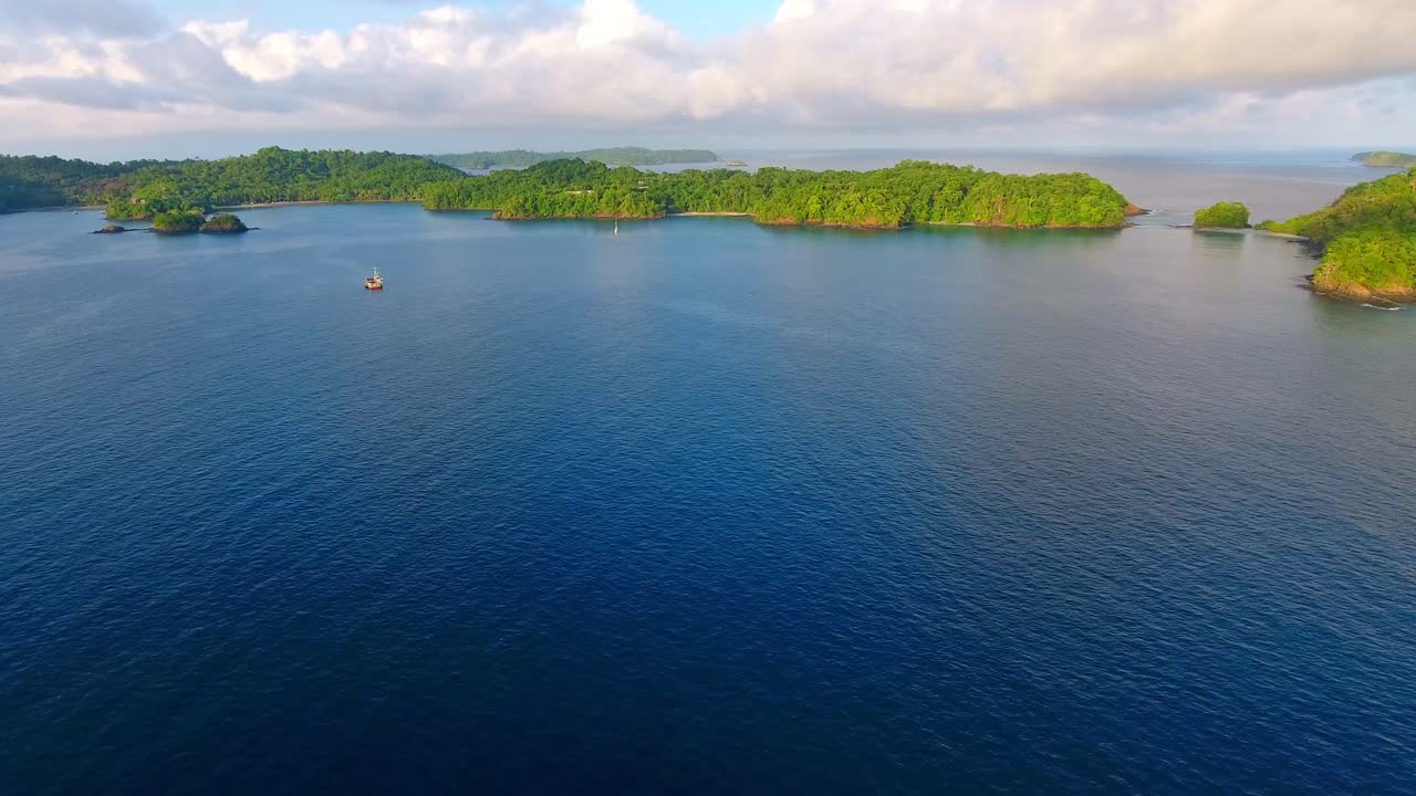 정박된 보트와 먼 섬의 전방 비행 보기에 대한 느린 호버링