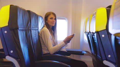 mujer usando el teléfono en el avión