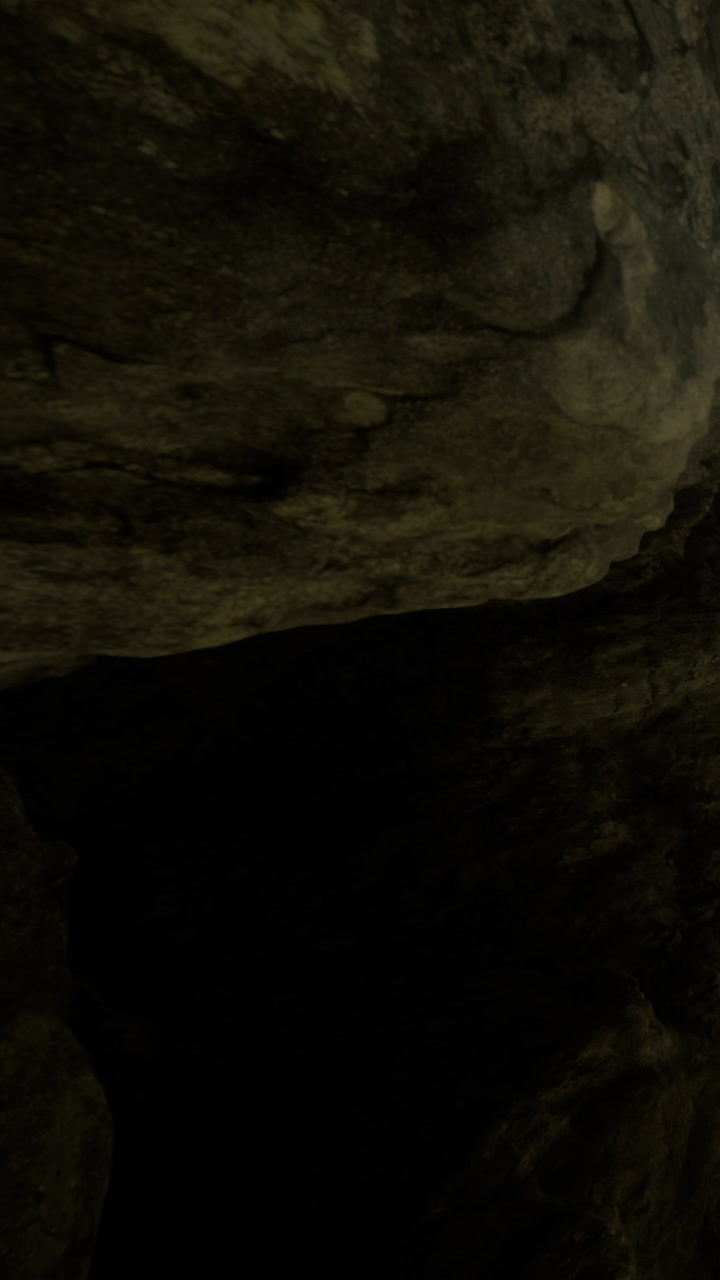 Exploring dark cave rock formations in a remote natural area in daylight