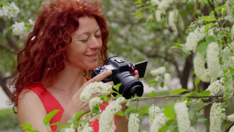 woman photographer in a spring blossom garden