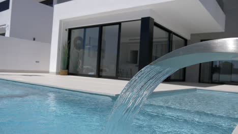 a luxury swimming pool with a water feature