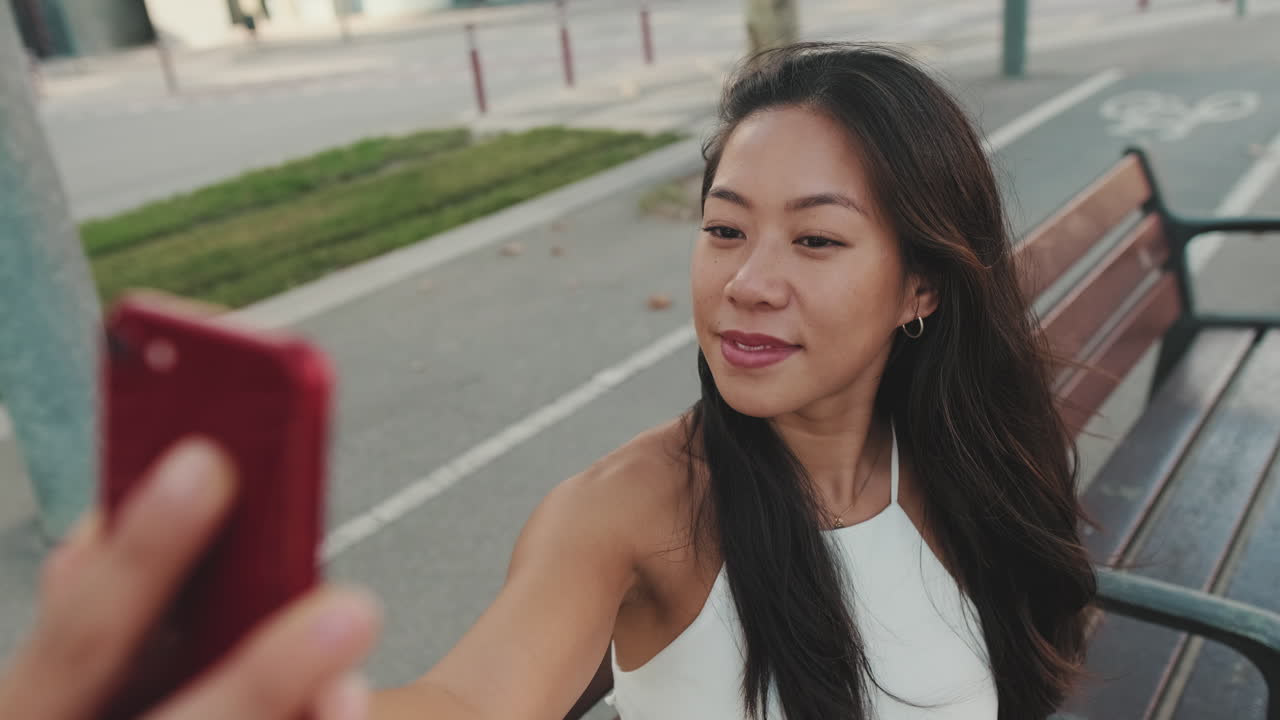 Donna che si fa un selfie su una panchina
