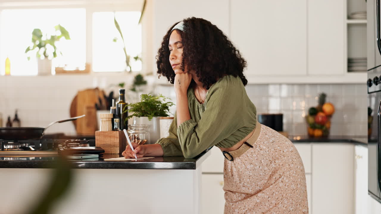 Donna che scrive una ricetta in una cucina moderna