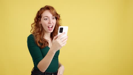 redhead woman reacts with surprise while looking at her phone
