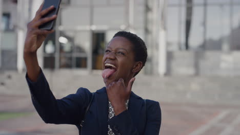 Porträt-Einer-Glücklichen-Afroamerikanischen-Geschäftsfrau,-Die-Ihr-Smartphone-Benutzt-Und-Ein-Selfie-Foto-Macht-Und-Gesichter-Macht.-Lustige-Professionelle-Schwarze-Frau,-Die-Mobile-Technologie-Genießt