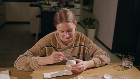 una chica pintando un huevo de pascua.