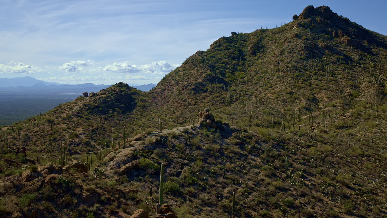 un avión no tripulado volando sobre una montaña desértica cubierta de cactus en tucson, arizona.
