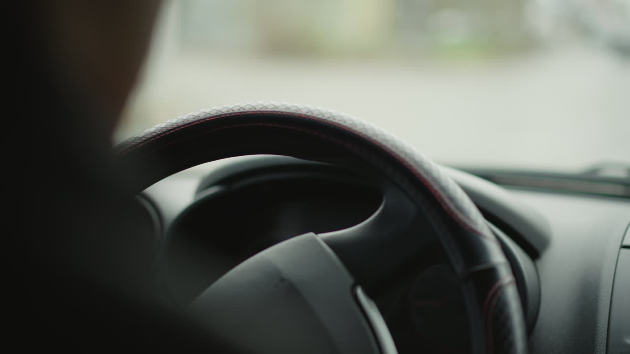 Green turn signal indicator blinking and clicking on dashboard as driver navigates busy urban intersection, close focus on illuminated lights and blurred city vehicles passing outside windshield