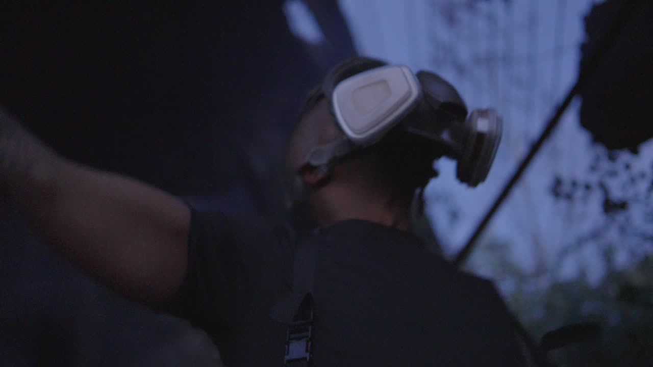 low angle view of a black man wearing a gas mask cursing the world