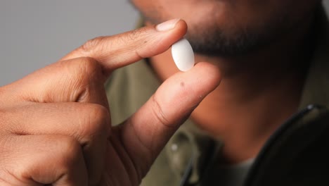 man holding a white pill