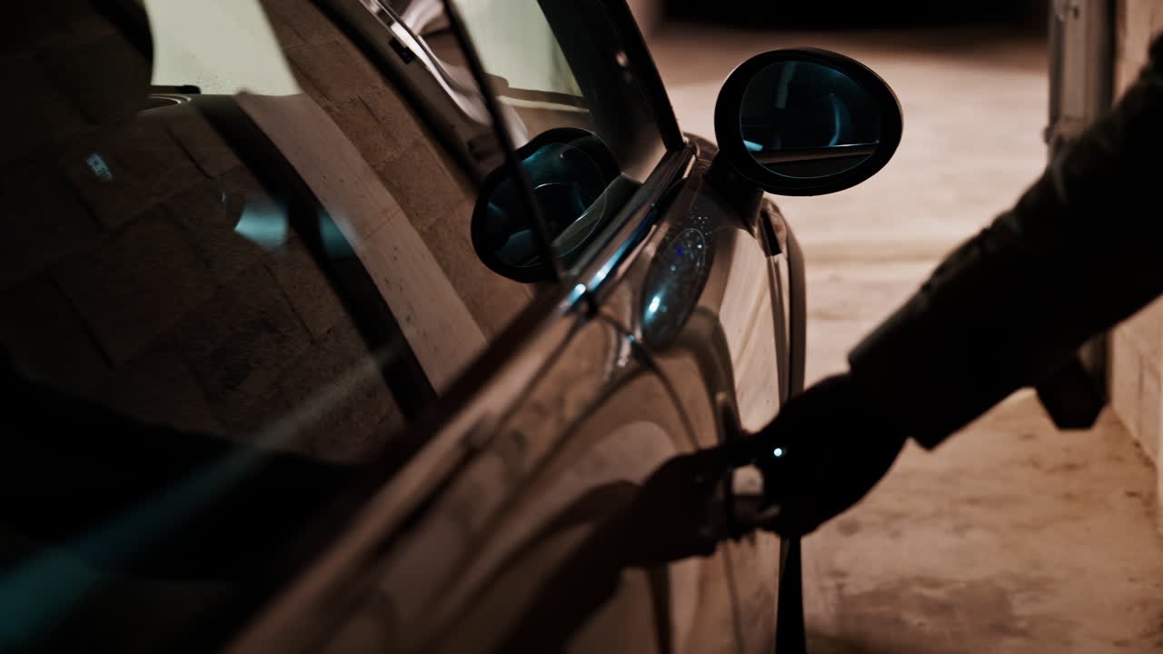 Close up of a woman's hand closing the car door in a parking lot