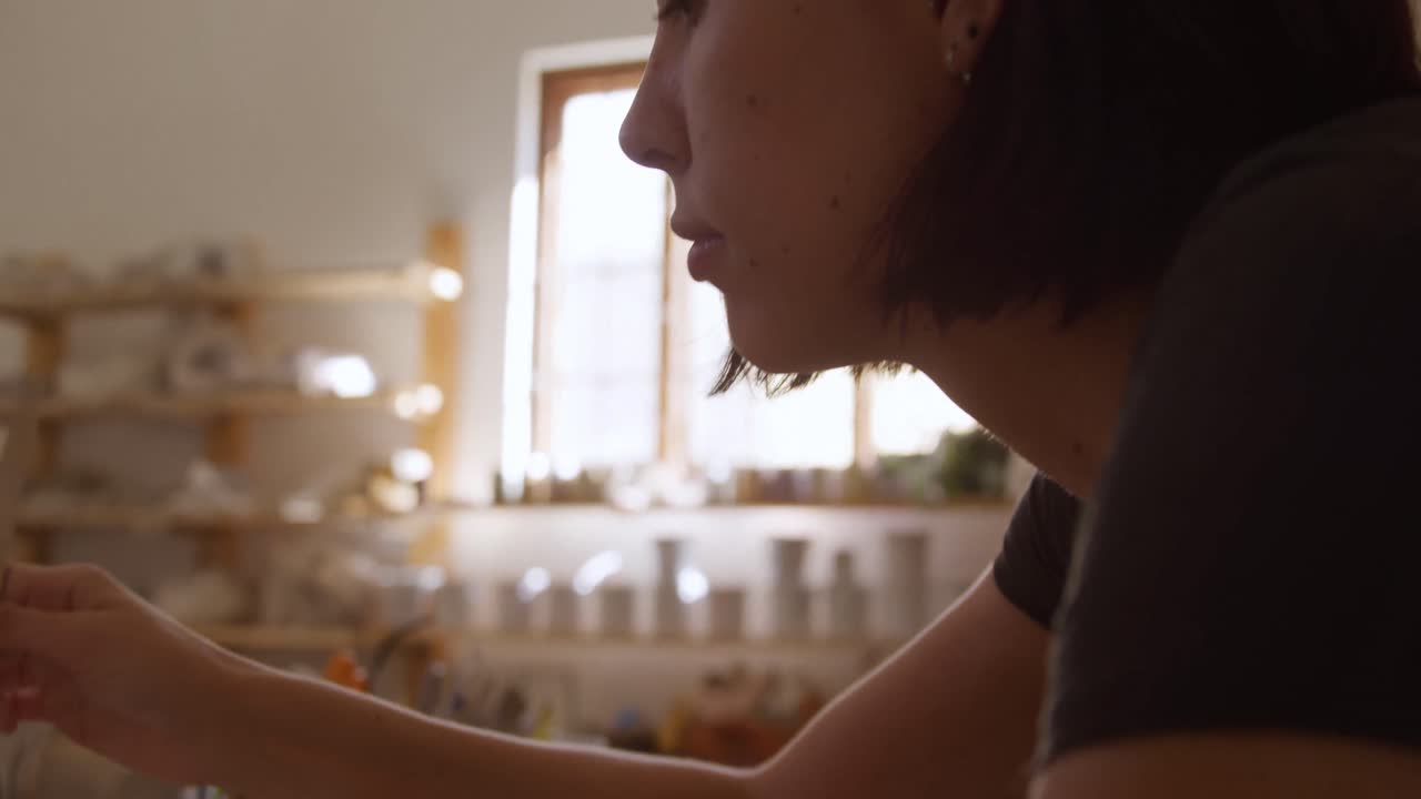 Young female potter working in her studio