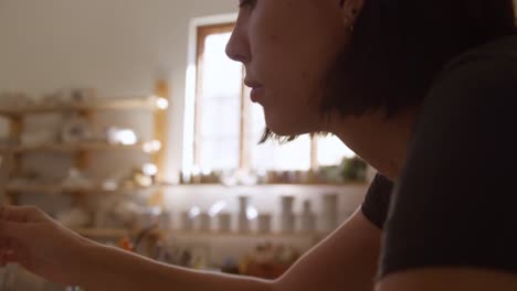 Young-female-potter-working-in-her-studio