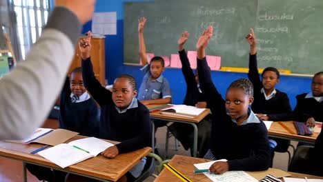 Schoolkids-hands-raised-in-the-classroom-4k