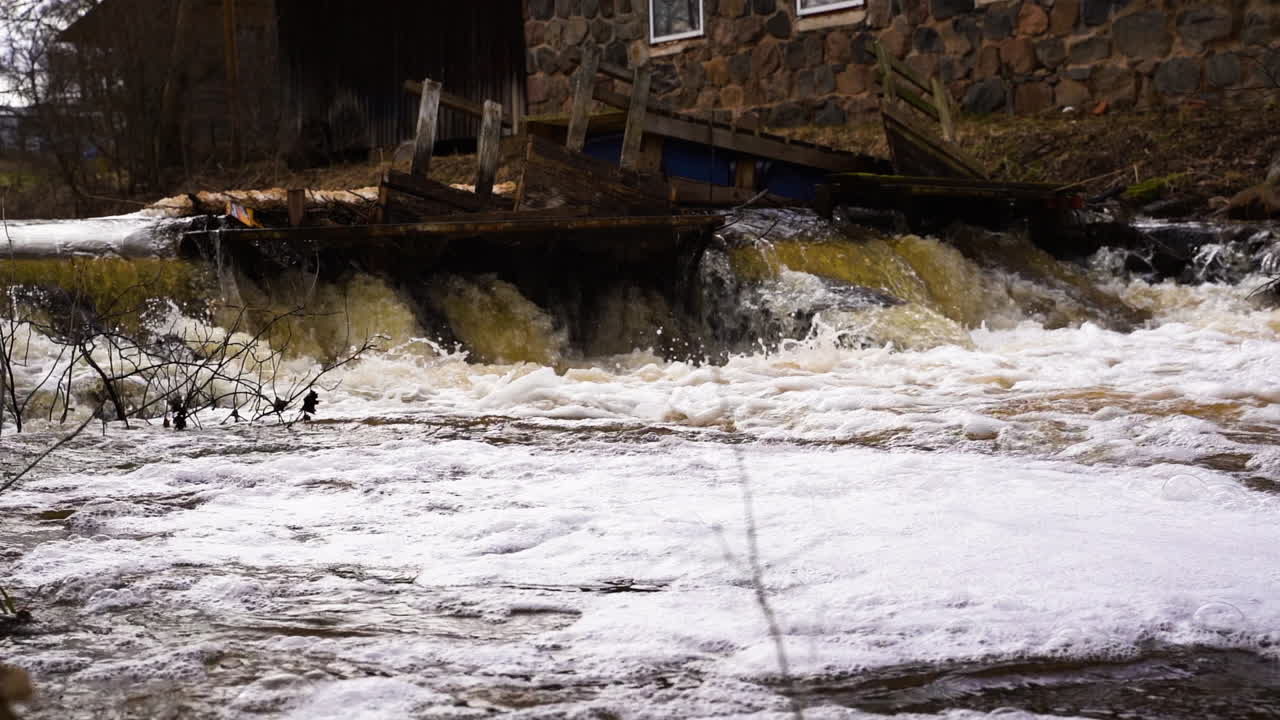 Spring water stream in river with foam, low angle view