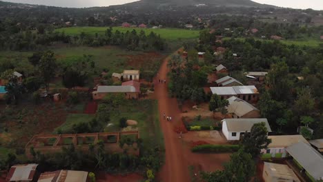 Aerial-of-Africans-walking-along-a-dirt-road-in-a-rural-village-in-stormy-rainy-weather