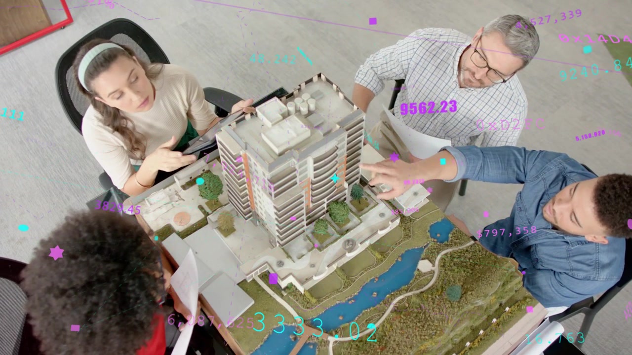 Team di progettazione che indica e ispeziona un modello in scala in sala riunioni con tablet, planimetrie e sovrapposizioni digitali.