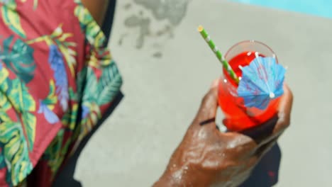 close-upof bllack man drinking cocktail drink near swimming pool 4k