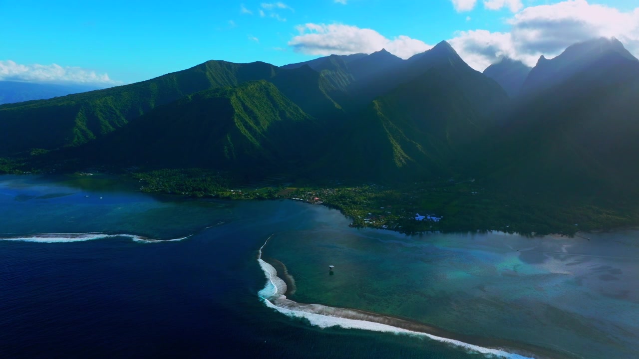 Surf Town of Teahupo'o Tahiti lagoon aerial drone harbor view French Polynesia Passe Havea coral reef wave South Pacific Ocean island landscape sunny sun rays volcano peaks coastline forward pan up