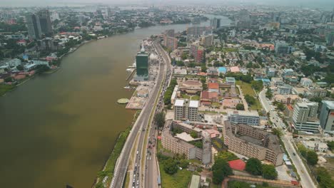 Traffic-and-cityscape-of-Falomo-Bridge,-Lagos-Law-school-and-the-Civic-centre-tower-in-Lagos-Nigeria