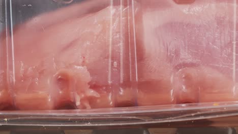 raw chicken breast in plastic packaging