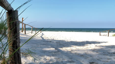 white sand beach overlooking the calm blue sea and bright sky in summer from the shore