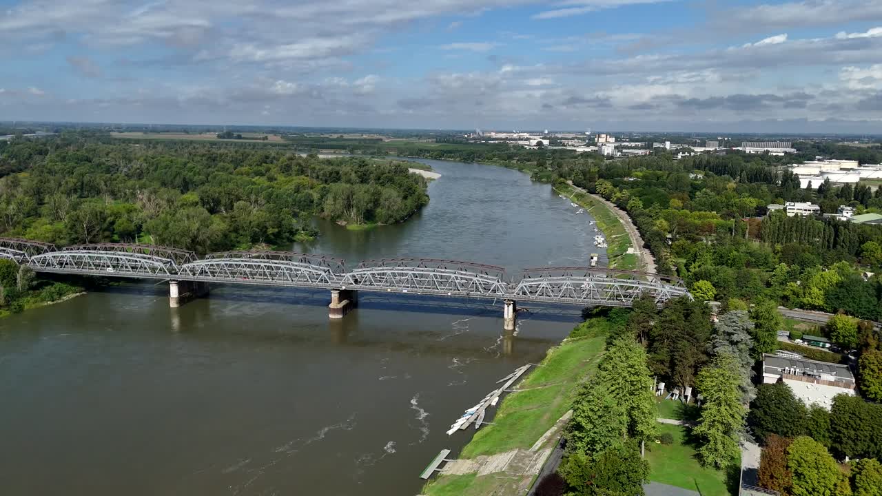 Panoramic aerial view capturing the impressive iron bridge viaduct gracefully spanning the wide Po River in Cremona Lombardy Italy with lush green trees lining the banks