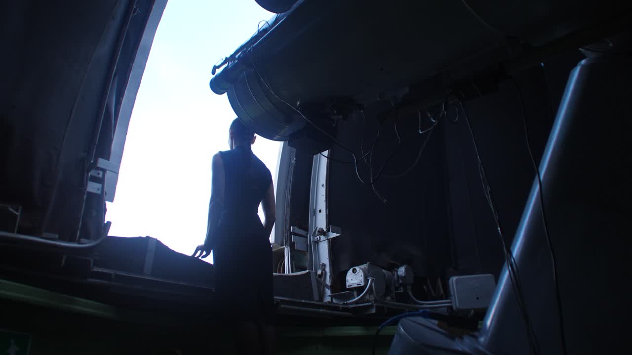 mujer observando a través de un telescopio en un observatorio