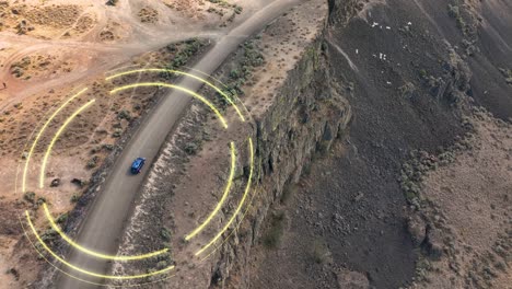 aerial view of a smart car navigating through a unique cliffside in the desert