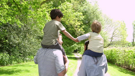 parents give sons ride on shoulders during walk shot on r3d