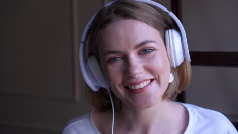smiling young girl in headphones posing at camera