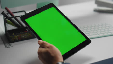 tableta de pantalla verde de primer plano en las manos. gerente de oficina sosteniendo un dispositivo de maqueta