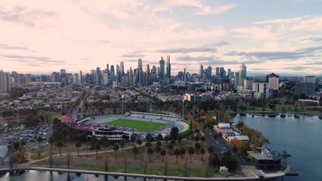 Das-Melbourne-Aquatic-Centre-Offenbart-Sich-Langsam-Mit-Melbourne-CBD-Im-Hintergrund-über-Dem-Albert-Park-Lake