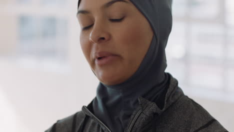 portrait beautiful young muslim woman chatting to friend in yoga class discussing healthy fitness lifestyle sharing training tips enjoying conversation in studio wearing headscarf