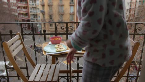 Una-Mujer-En-Pijama-Deja-Sabrosas-Arepas-De-Desayuno-En-La-Mesa-Del-Balcón-El-Día-De-Invierno-Sin-Rostro