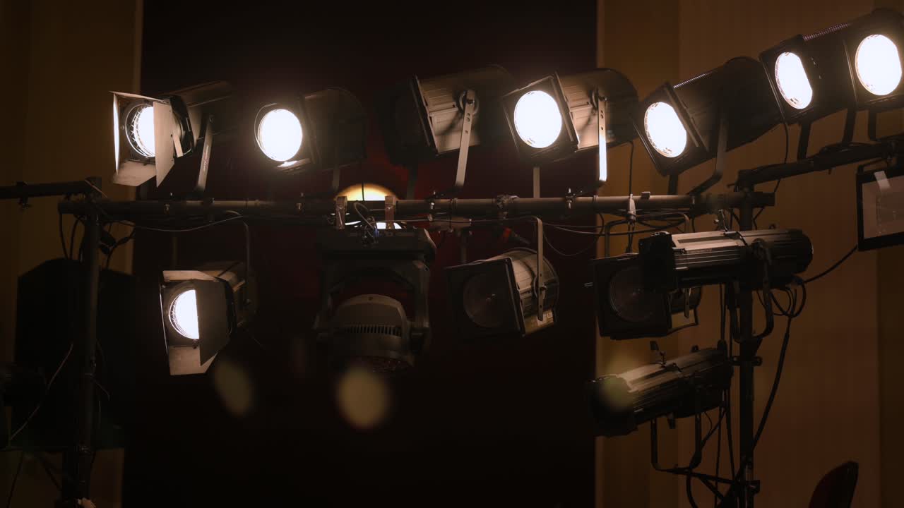 Revealing shot with theater stage lights, white light, handheld