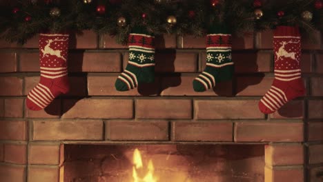 calcetines de regalo de navidad cuelgan sobre la chimenea donde arde el fuego