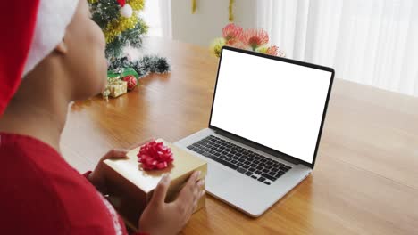Afroamerikanische-Frau-Mit-Weihnachtsmütze-Macht-Einen-Laptop-Weihnachtsvideoanruf,-Mit-Platz-Für-Kopien-Auf-Dem-Bildschirm