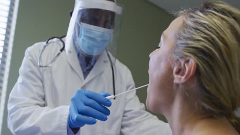 paciente femenina diversa y médico con máscara de rostro haciendo prueba de swab de covid