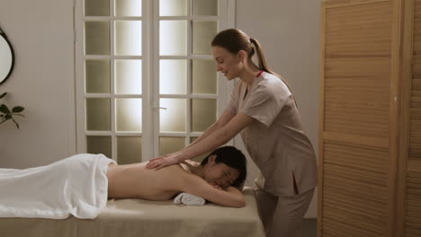 mujer recibiendo un masaje relajante en la espalda en un spa