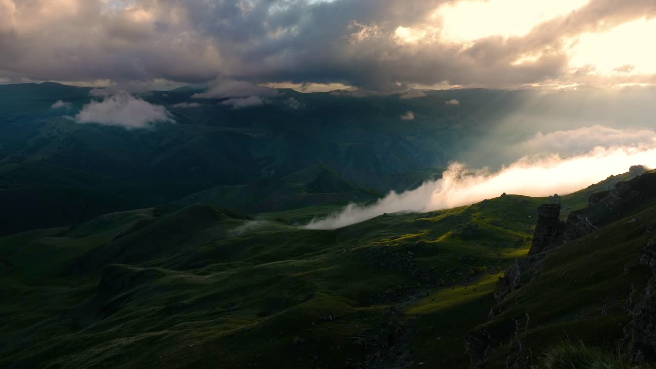nubes bajas sobre una meseta montañosa en los rayos del atardecer. atardecer en la meseta de bermamyt norte del cáucaso, karachay-cherkessia, rusia.