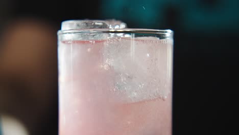 camarero llenando el resto de un vaso medio lleno de hielo