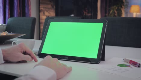 hombre de pantalla verde bloqueando su tableta pc