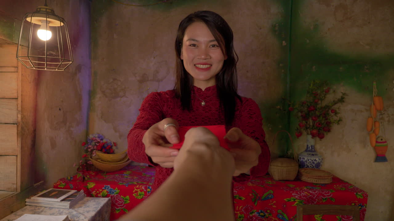 POV smiling asiatic woman donate envelope with money celebrating Chinese New Year