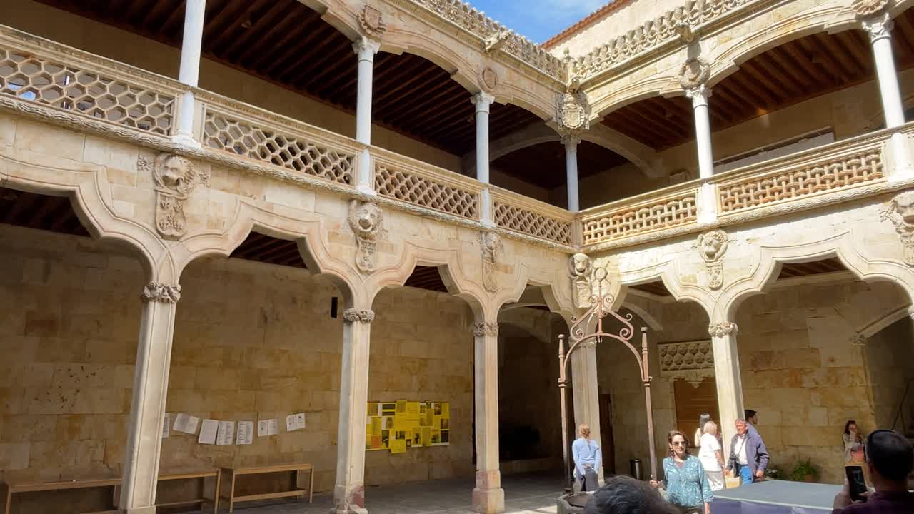 filming of the two-story interior patio of the Casa de las Conchas 15th-16th centuries where we see its beautiful work with arches and columns and Mudejar and Renaissance decoration, tourists appear